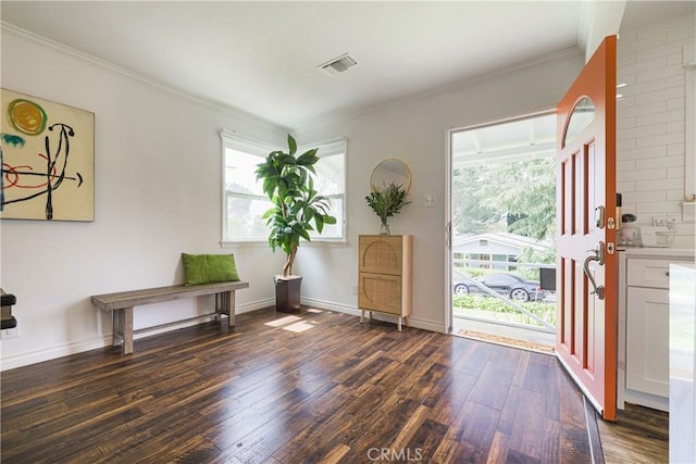 entrance foyer with visible vents, ornamental molding, wood finished floors, and a wealth of natural light