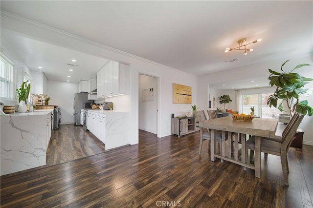 dining space with baseboards, dark wood finished floors, and visible vents