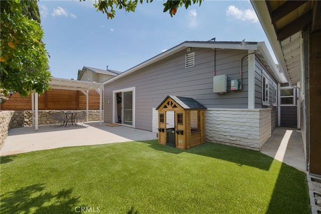 rear view of property with a pergola, a yard, and a patio