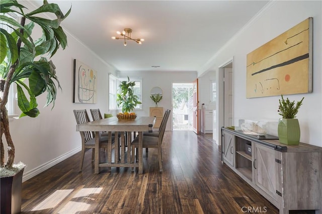 dining area featuring dark wood-type flooring, baseboards, crown molding, and a notable chandelier