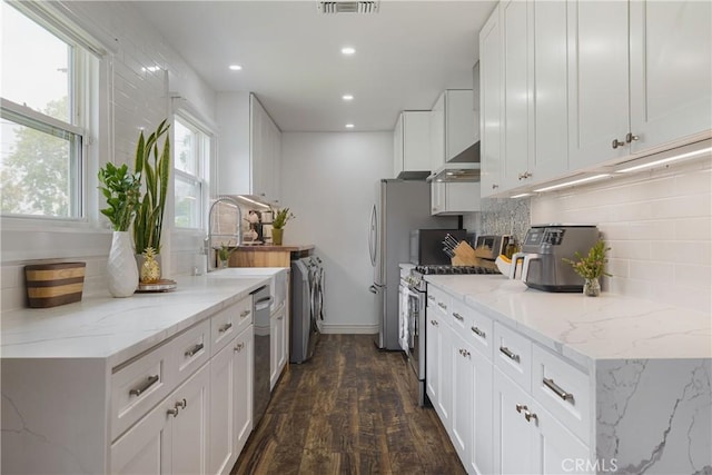 kitchen featuring washer / clothes dryer, dark wood-style floors, white cabinets, tasteful backsplash, and stainless steel appliances