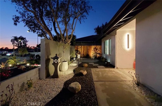 1427 N Cannon St, Orange, CA 92869 - view of side of home featuring fence, a patio area, and stucco siding