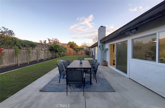 1427 N Cannon St, Orange, CA 92869 - patio terrace at dusk with a yard, outdoor dining area, and a fenced backyard