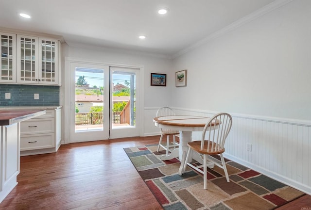dining room with crown molding, wainscoting, recessed lighting, and wood finished floors