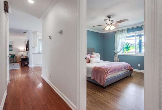 bedroom featuring crown molding, baseboards, and wood finished floors
