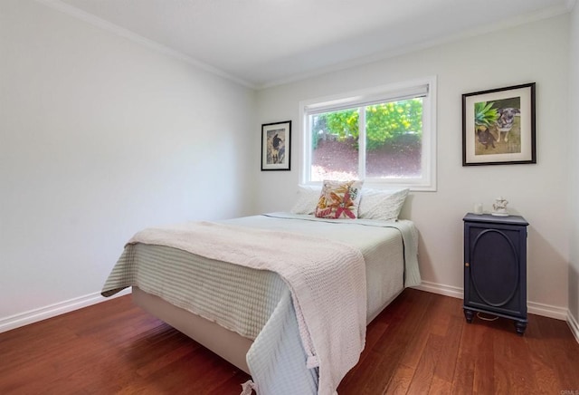 bedroom with baseboards, ornamental molding, and wood finished floors