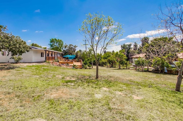 view of yard featuring a wooden deck and fence