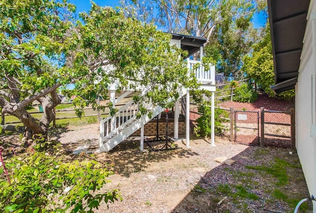 view of yard with fence, a gate, and stairs