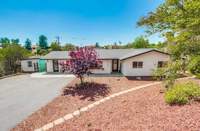 ranch-style home with driveway and stucco siding