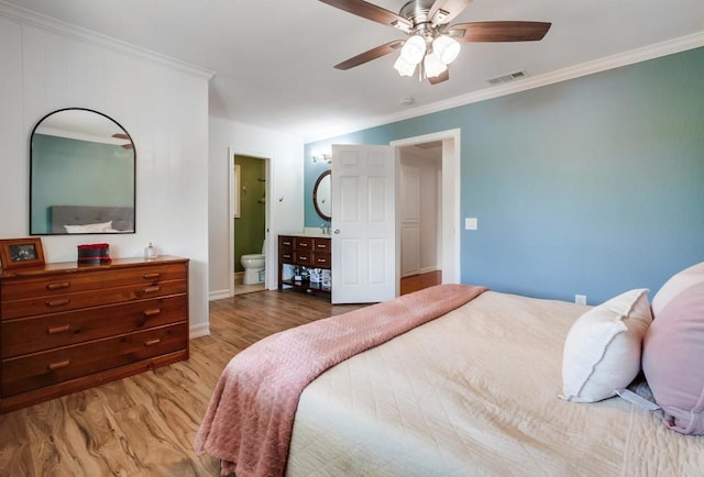 bedroom featuring connected bathroom, light wood-style flooring, baseboards, visible vents, and ornamental molding