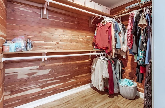 walk in closet with wood finished floors