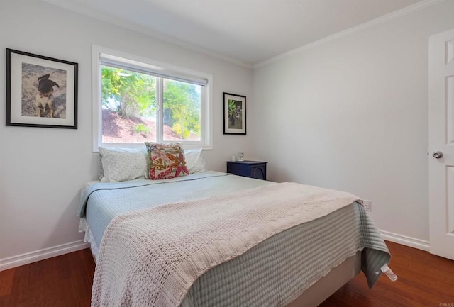 bedroom featuring crown molding, baseboards, and wood finished floors