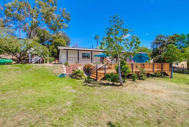 rear view of house featuring a yard, a deck, and stairway