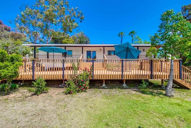 rear view of house with a yard and a deck