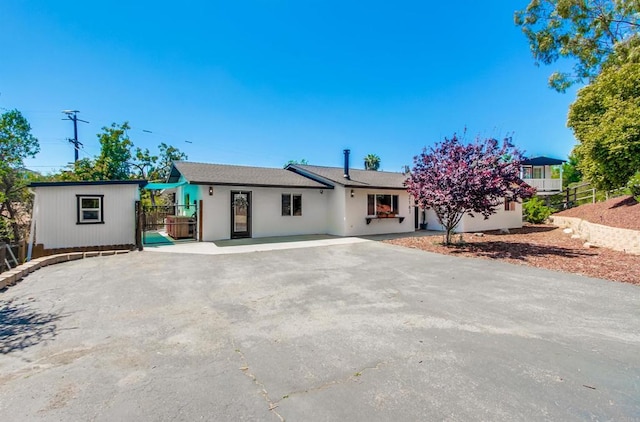 single story home featuring stucco siding and fence