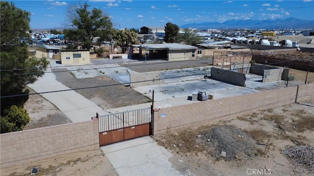 view of yard with a gate, a mountain view, and a fenced front yard