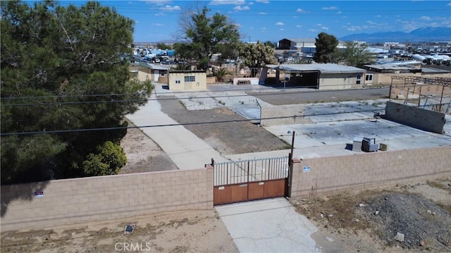 view of yard with a gate, a fenced front yard, and a mountain view