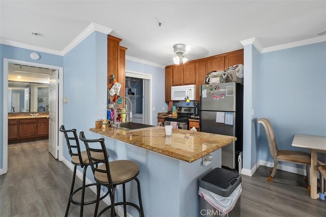 1980 Las Colinas Cir Unit 208, Corona, CA 92879 - kitchen with stainless steel appliances, a sink, dark wood-style floors, a kitchen breakfast bar, and baseboards