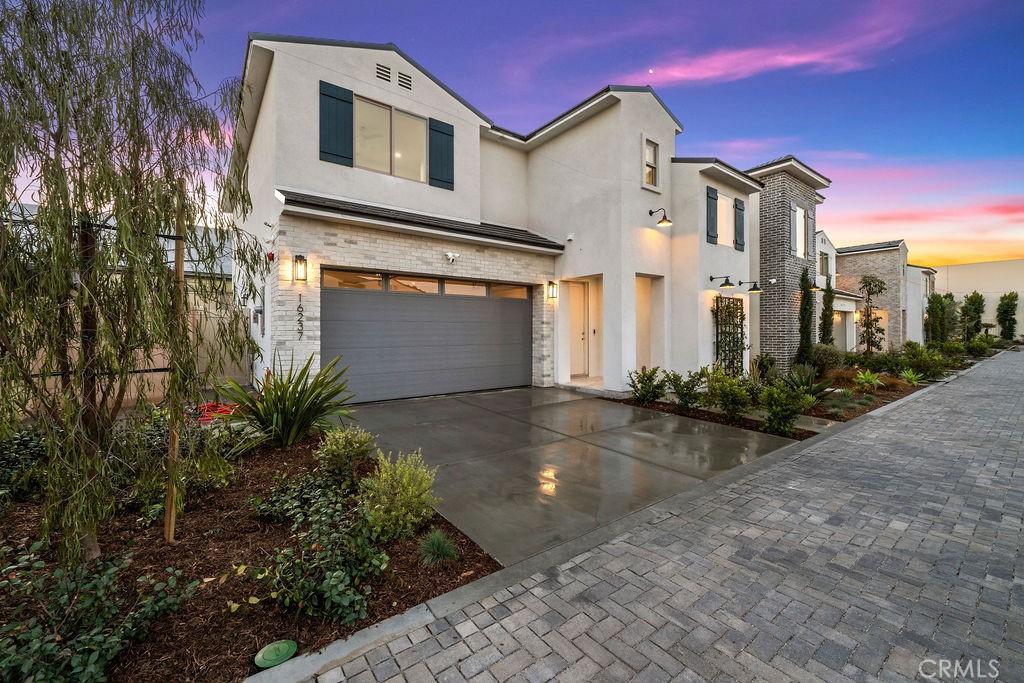 view of front of home with a garage, stucco siding, concrete driveway, and stone siding