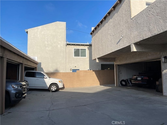 view of home's exterior with a garage, fence, and stucco siding