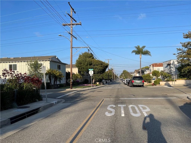 view of street with curbs, traffic signs, sidewalks, and a residential view