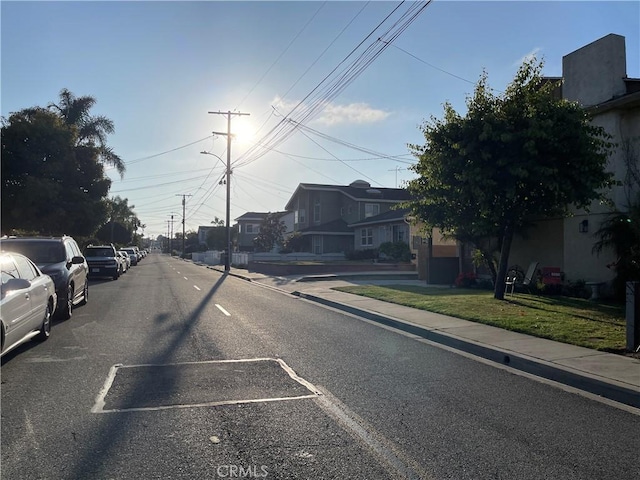 view of road with street lighting, curbs, sidewalks, and a residential view