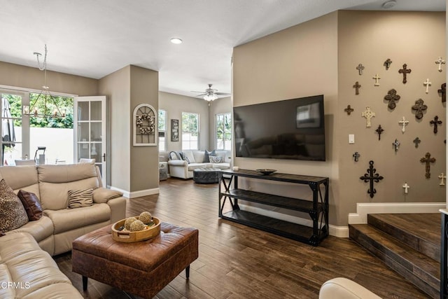 living area featuring baseboards, plenty of natural light, ceiling fan, and dark wood-type flooring