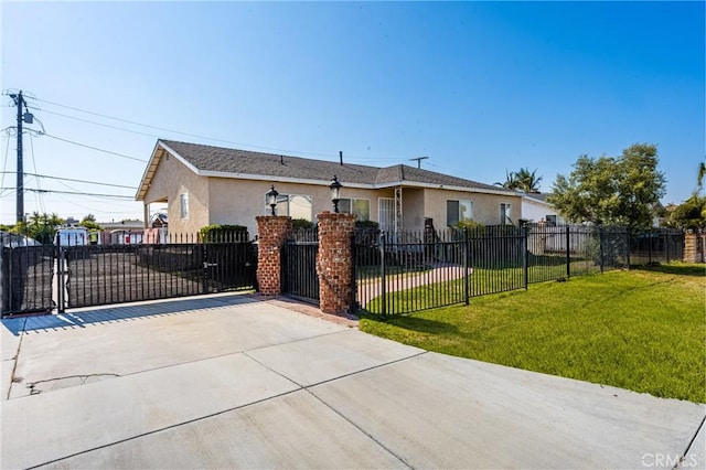 view of front facade featuring stucco siding, a front yard, a gate, concrete driveway, and fence private yard