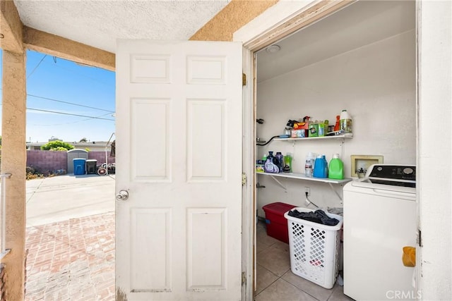 clothes washing area with washer / clothes dryer, laundry area, and tile patterned floors