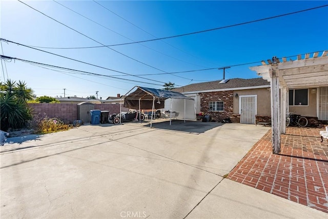 rear view of property featuring fence, a patio, a gazebo, and stucco siding