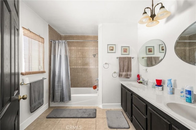 bathroom with baseboards, a sink, tile patterned floors, and a notable chandelier