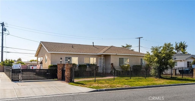 view of front facade with a gate, a fenced front yard, stucco siding, and driveway