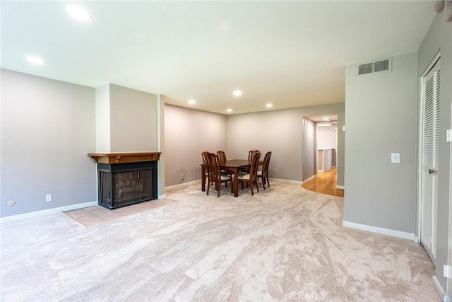 carpeted dining space with a multi sided fireplace, recessed lighting, baseboards, and visible vents