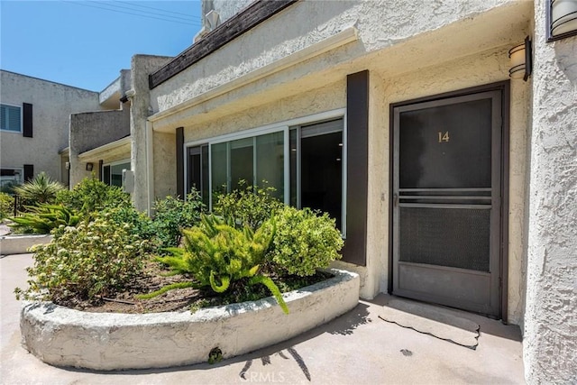 view of exterior entry featuring stucco siding