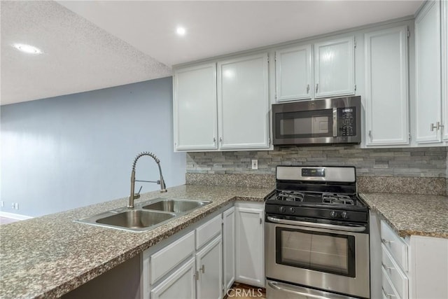 kitchen featuring backsplash, white cabinets, appliances with stainless steel finishes, and a sink