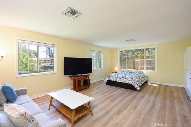 bedroom featuring light wood finished floors and baseboards
