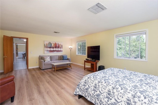 bedroom with light wood-type flooring and baseboards