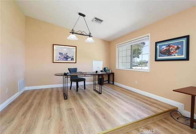 office area with light wood-style flooring, baseboards, and lofted ceiling
