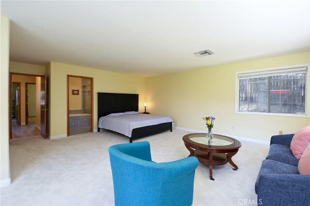 bedroom with light colored carpet and baseboards