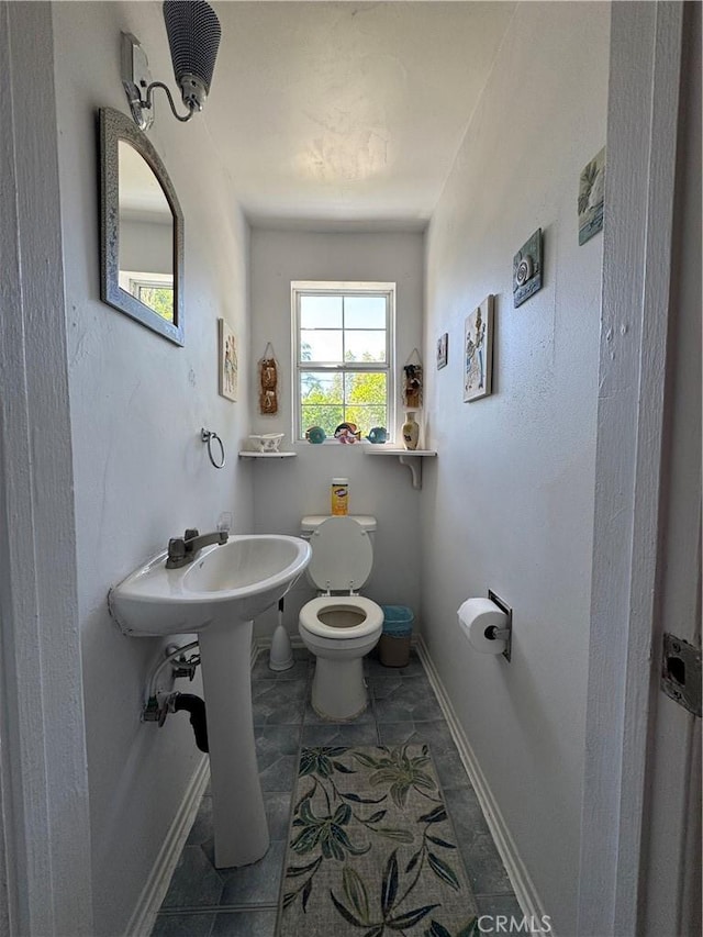 bathroom with baseboards and toilet