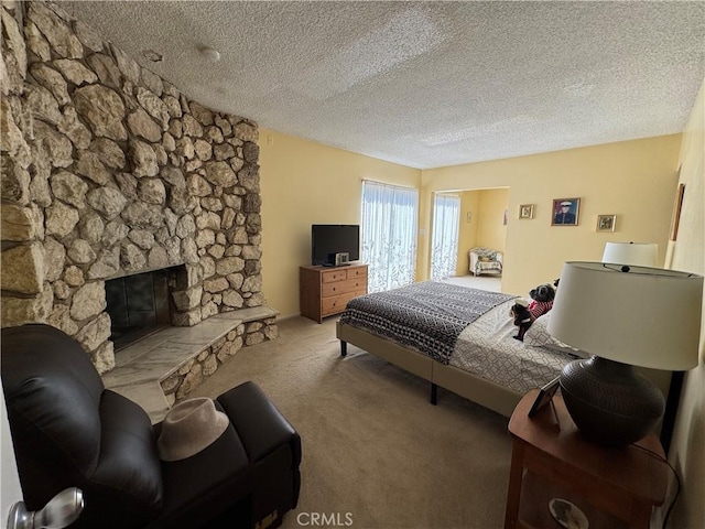 bedroom with carpet floors, a stone fireplace, and a textured ceiling