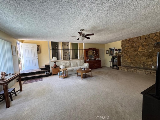 living area with a ceiling fan, carpet, and a textured ceiling