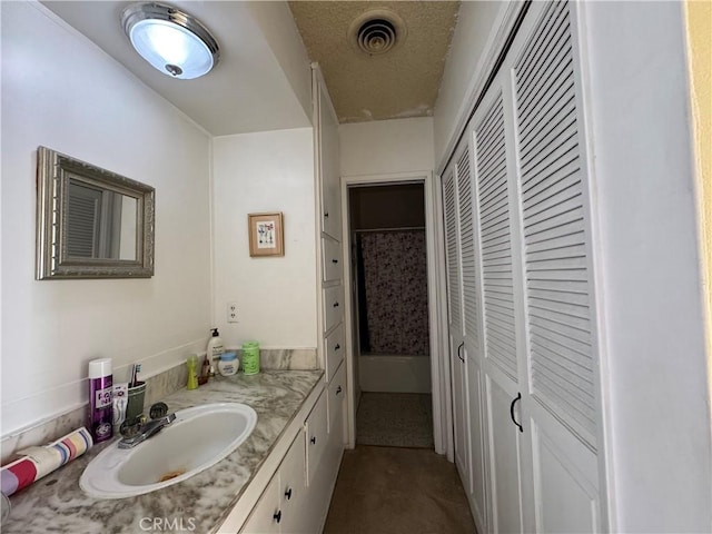 bathroom with vanity, a closet, and visible vents