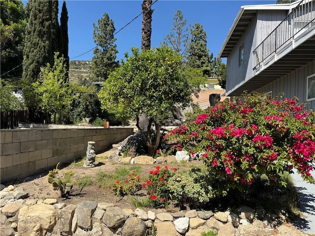 view of yard featuring fence and a balcony