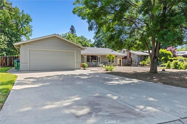 single story home featuring fence, driveway, and a garage