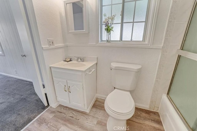9451 Canterbury Ave, Arleta, CA 91331 - bathroom with toilet, wood finished floors, vanity, and bath / shower combo with glass door