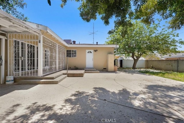 9451 Canterbury Ave, Arleta, CA 91331 - rear view of house with a patio, a shed, an outdoor structure, fence, and stucco siding