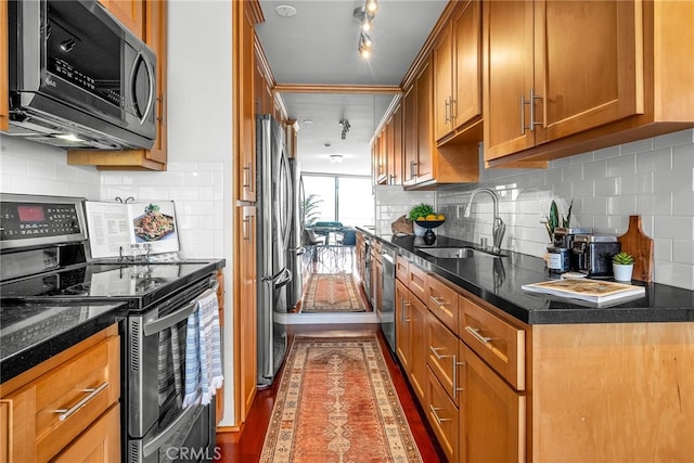 531 Esplanade Unit 714, Redondo Beach, CA 90277 - kitchen with stainless steel appliances, a sink, brown cabinetry, decorative backsplash, and dark wood finished floors