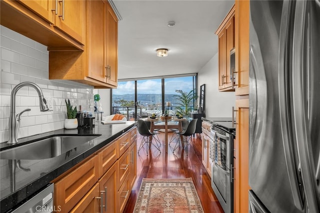 531 Esplanade Unit 714, Redondo Beach, CA 90277 - kitchen featuring stainless steel appliances, dark wood-type flooring, a sink, dark stone countertops, and brown cabinetry