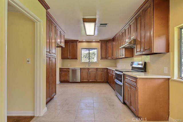 kitchen featuring a sink, light countertops, stainless steel appliances, under cabinet range hood, and visible vents